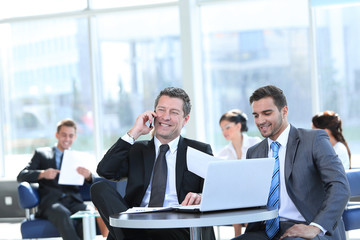 serious businessman talking on mobile phone sitting at your Desk