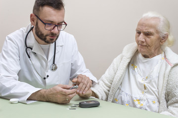 Lekarz Diabetolog trzyma palec wskazujący bardzo starej kobiety do nakłucia igłom w celu zbadania poziomu cukru we krwi. - obrazy, fototapety, plakaty