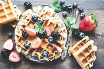 Belgian waffles with strawberries, and blueberries, homemade healthy breakfast, toned image, selective focus