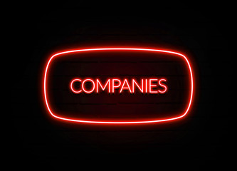 Companies neon sign on brick wall background.