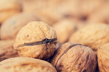 Vintage filtered close up of ripe walnuts on wooden table background copy space