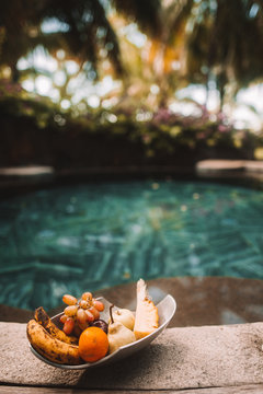 Close-up of fruits in a bowl beside the pool