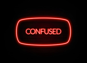 Confused neon sign on brick wall background.