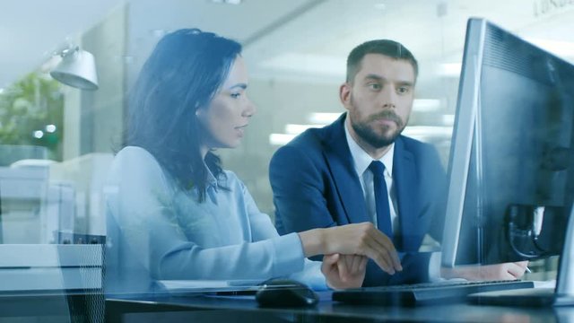 In the Office Businesswoman and Businessman Have Conversation, Share Personal Computer Trying to Solve Problem. Shot on RED EPIC-W 8K Helium Cinema Camera.
