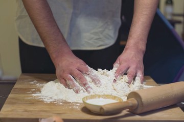 Obraz na płótnie Canvas Hands rumple dough in kitchen