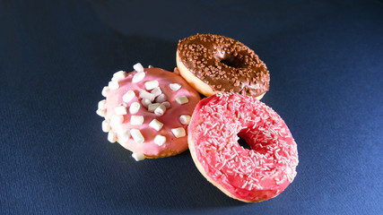 Colorful donuts on stone table. 