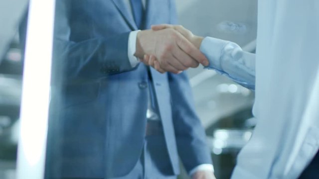 Close-up of the Businesswoman and Businessman Shaking Hands with Emphasis on the Handshake. Shot on RED EPIC-W 8K Helium Cinema Camera.