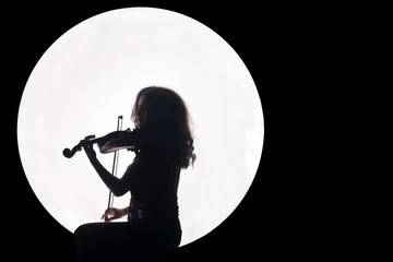 Silhouette of a girl in a white circle with a violin in her hands. Concept. Music for the full...
