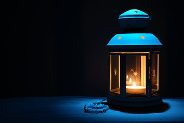 Holy month of Ramadan Karim background. Bright lantern and beads on the sand with a copy space