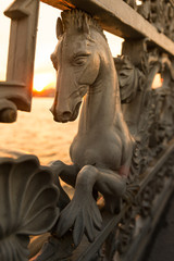 Fototapeta na wymiar Iron railings of the fence with horses on Annunciation bridge decorated with hippocampus or hippocamp, often called a sea-horse, close up, vertical/