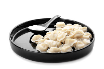 Plate with tasty dumplings and sour cream on white background