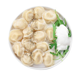 Plate with tasty dumplings and sour cream on white background