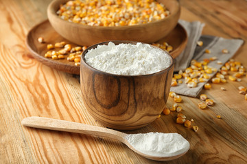 Bowl and spoon with corn starch on wooden table