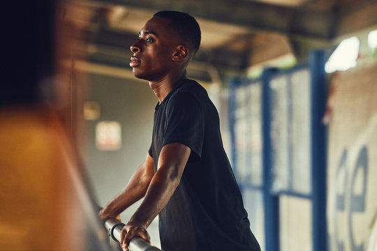 Thoughtful athlete leaning on railings
