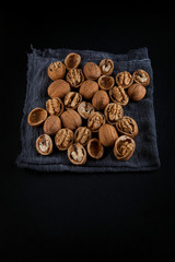 Beautifully presented walnuts on dark slate plate kitchen with napkin table can be used as background