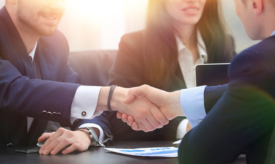 handshake financial partners sitting at the table