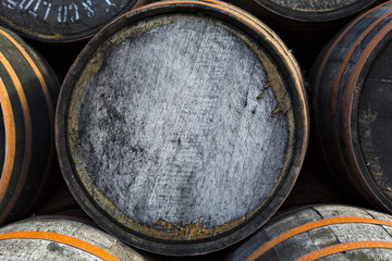 Stacked pile of old wooden barrels and casks at whisky distillery in Scotland