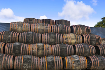 Stacked pile of old wooden barrels and casks at whisky distillery in Scotland