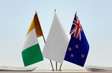 Flags of Ivory Coast and New Zealand with a white flag in the middle