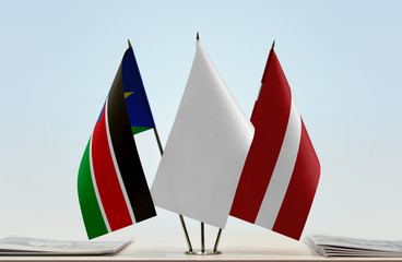 Flags of South Sudan and Latvia with a white flag in the middle