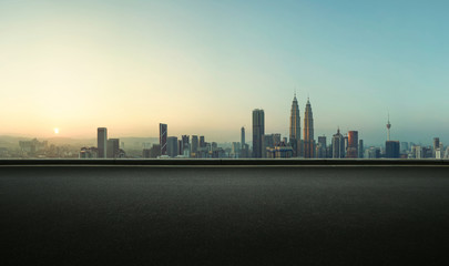 Fototapeta na wymiar Asphalt empty road side with Kuala Lumpur city skyline background . Sunrise scene .