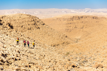 Fototapeta na wymiar Four backpackers hiking trail, Negev desert, Israel.