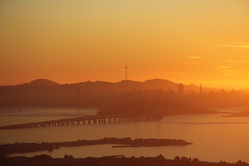 Sunset in the Bay Area San Francisco over bay and with bridge and city