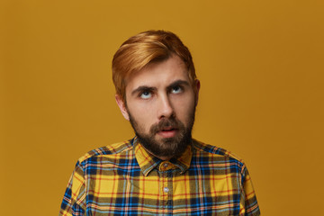 Boring to death! Young bearded male, wearing yellow t-shirt, dyed hair feels bored and thinkin...
