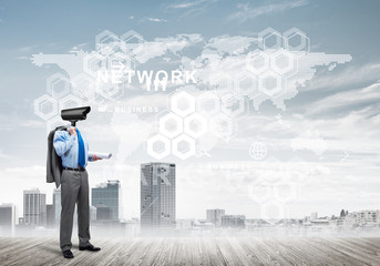 Camera headed man standing on wooden floor against modern cityscape