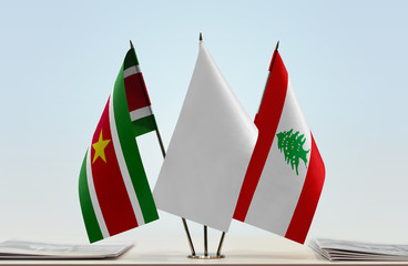 Flags of Suriname and Lebanon with a white flag in the middle