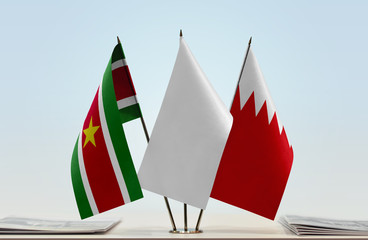 Flags of Suriname and Bahrain with a white flag in the middle