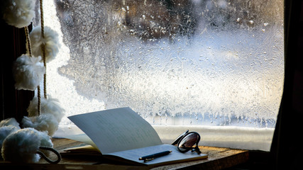 Notebook with glasses in winter window spring break vacation planning conceptual image