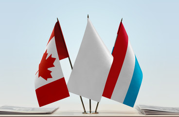 Flags of Canada and Luxembourg with a white flag in the middle