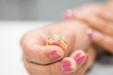 Gold ring with diamond heart in woman hand
