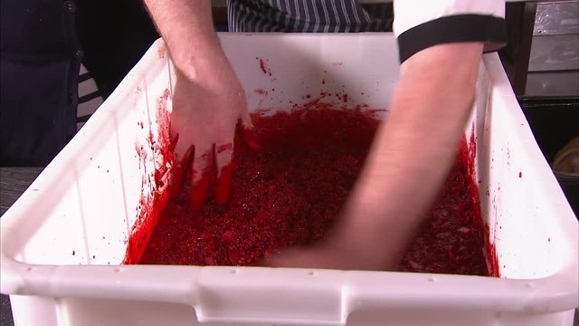 A close up shot of a man's hand as he mixes a pork mixture using his hands.