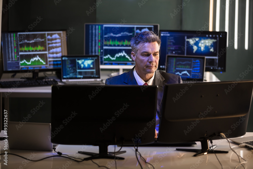 Poster stock market broker looking at multiple computer screen