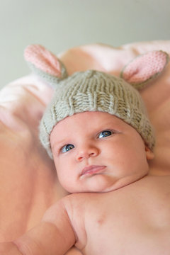 closeup of a newborn baby in a knit bunny ear hat
