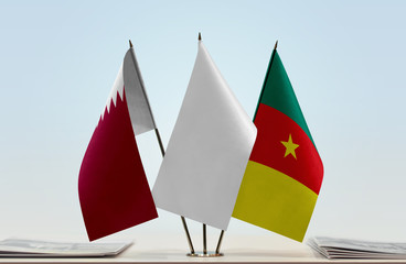 Flags of Qatar and Cameroon with a white flag in the middle