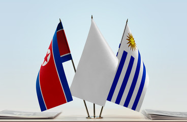 Flags of North Korea and Uruguay with a white flag in the middle