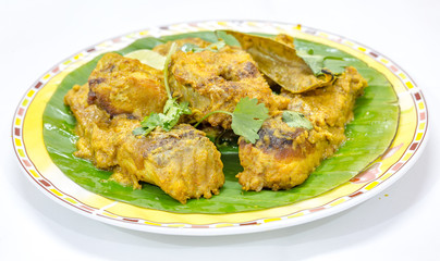 Tasty Bengali food dish of masala Rohu fish curry on banana leaf with coriander
