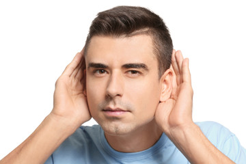 Young man with hearing problem on white background