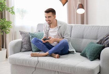 Young man playing video games at home