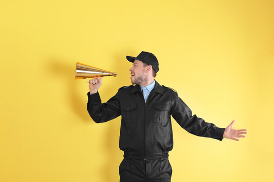 Male security guard with megaphone on color background