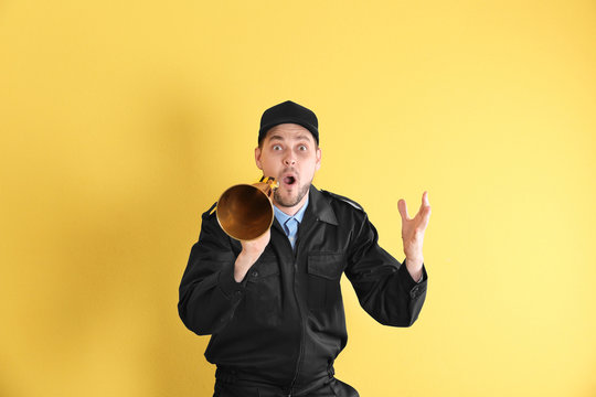 Male security guard with megaphone on color background