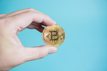 Fototapeta na wymiar bitcoin ビットコインを手にもつ　金貨パターン　 水色背景