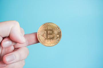 bitcoin  ビットコインを手にもつ　金貨パターン　 水色背景