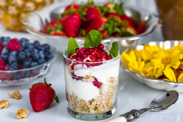 Breakfast with muesli, yogurt, fruits and edible flowers