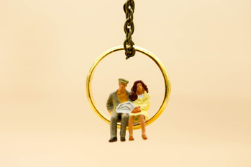 Miniature people : Couple of love sitting on  the ring,Love and Valentine's day concept.