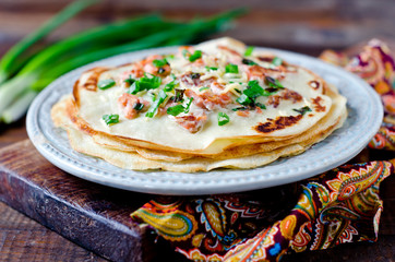 Pancakes with fish, cheese and green onions