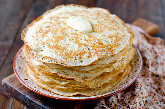 Yeast pancakes with butter on a plate